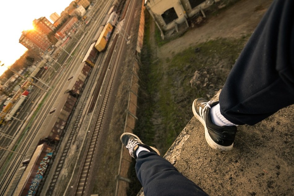 man in sports shoes over the railway
