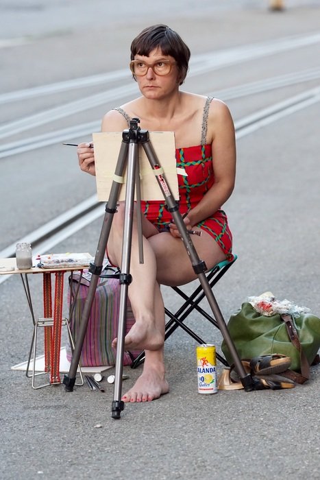woman draws sitting on the street