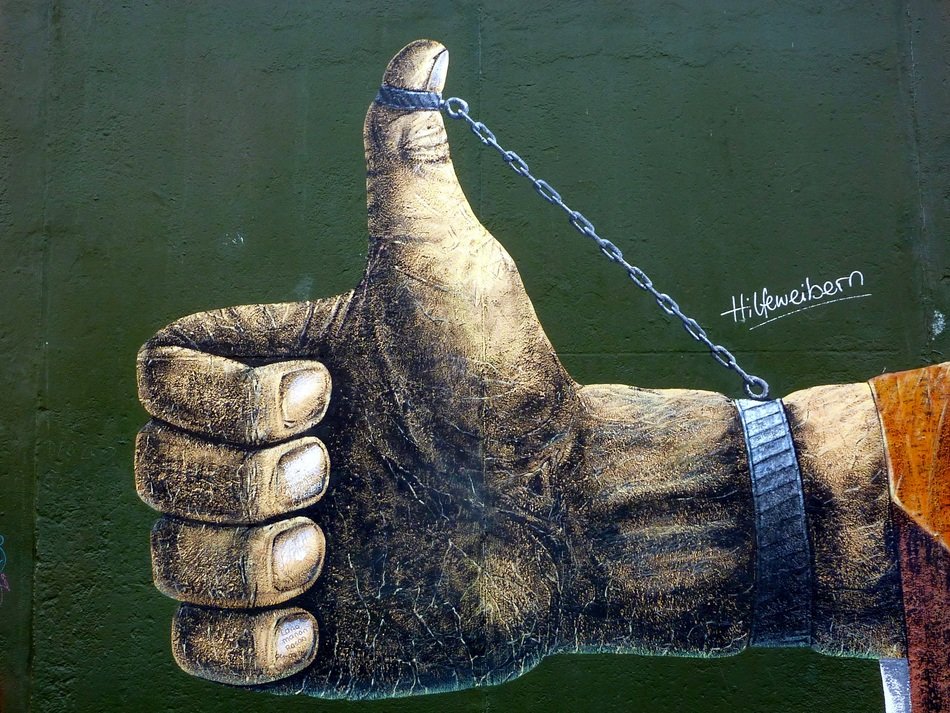 hand with chained thumb up, graffiti on wall