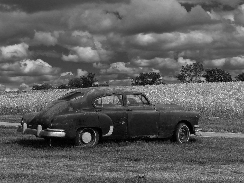Black and white photo of the retro car on the field