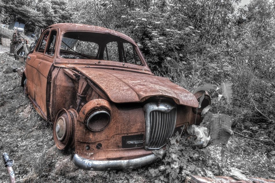 old broken car in the woods