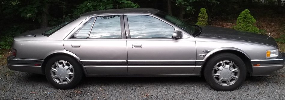 cadillac stands on the edge of the road
