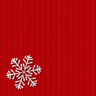 Paper snowflake on red knitted background