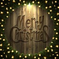 Merry Christmas lettering on Wooden background with bright wreath