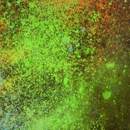 Neon paint splattered texture on dark background