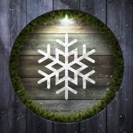 Paper Flake on wooden Background with Christmas wreath and snow