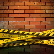Caution ribbons on brick wall