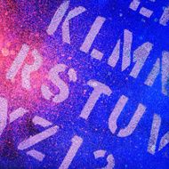 Paint splattered background in blue and pink with text