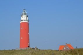 brown lighthouse and small house