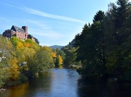 middle ages castle by a river in autumn