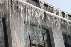 A lot of icicles on the roof of the building