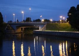 illuminated bridge over the river at dusk