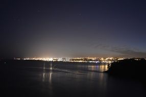 view of the lights of the night city from the sea