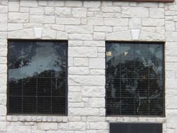 two glass windows on the imestone house walls