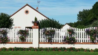 village house behind fence at summer, france