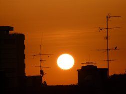 orange sunset over the city antennas