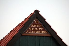 inscription in gold font on the roof of a building