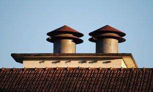 fireplaces on a roof at blue sky background