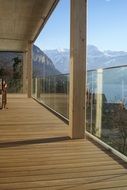 wooden terrace in a glass enclosure amidst a picturesque landscape