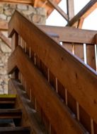 wooden staircase near a stone wall