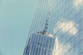 reflection of a tower in the windows of an office building