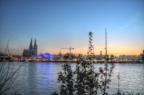 view of city at sunset through rhine river, germany, cologne