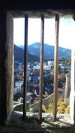 view of city through bars in window of tower of ancient fortress, france