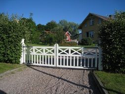 white gate near green bushes