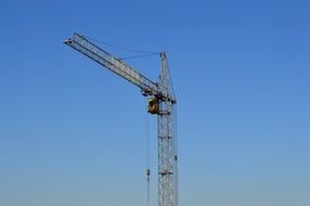 Boom of a construction crane against a background of clear sky