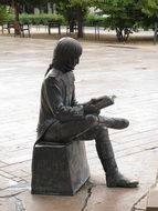 bronze statue of a man with a book