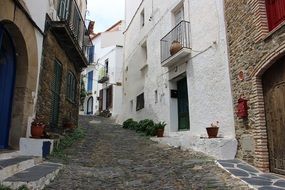 narrow road between houses with the balconies