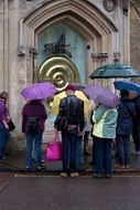 people under umbrellas in front of the building