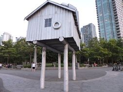 small wooden house near high residential buildings
