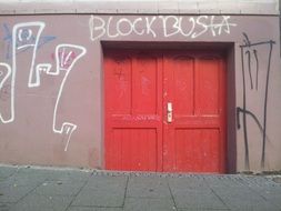 graffiti on a wall and Wooden red door in the building