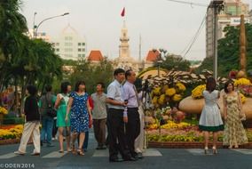 people walking street flowers city