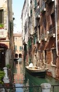 boat on channel in old grunge alley, italy, venice