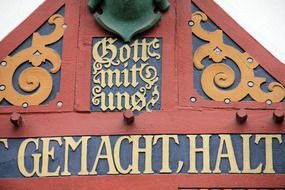 golden inscription on the roof of the colorful farm