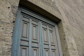 weathered blue wooden door in aged grey stone wall