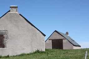 gray rural houses on a green field in france