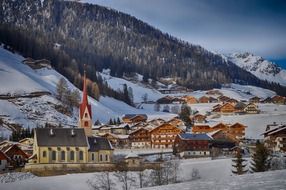 church in village at mountain side, scenic winter landscape, italy, gsies
