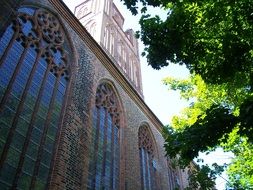 wall of the gothic church in the shade of trees