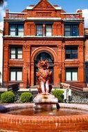 sculpture of a wolf in a fountain in front of the building, usa, georgia, savannah