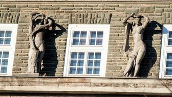 white windows and sculptures on the background of the building facade