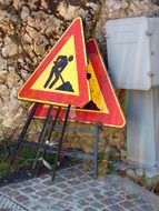 construction street signs near the wall