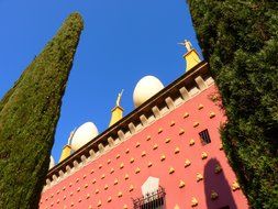 golden elements on the pink facade of the museum