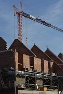 crane over the construction of a brick building