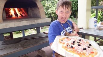 boy cooking pizza in Italy