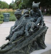 children on sled, bronze sculpture in park