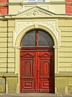 red wooden entrance door in old stone facade, poland, bydgoszcz