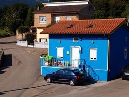 car near the small blue house